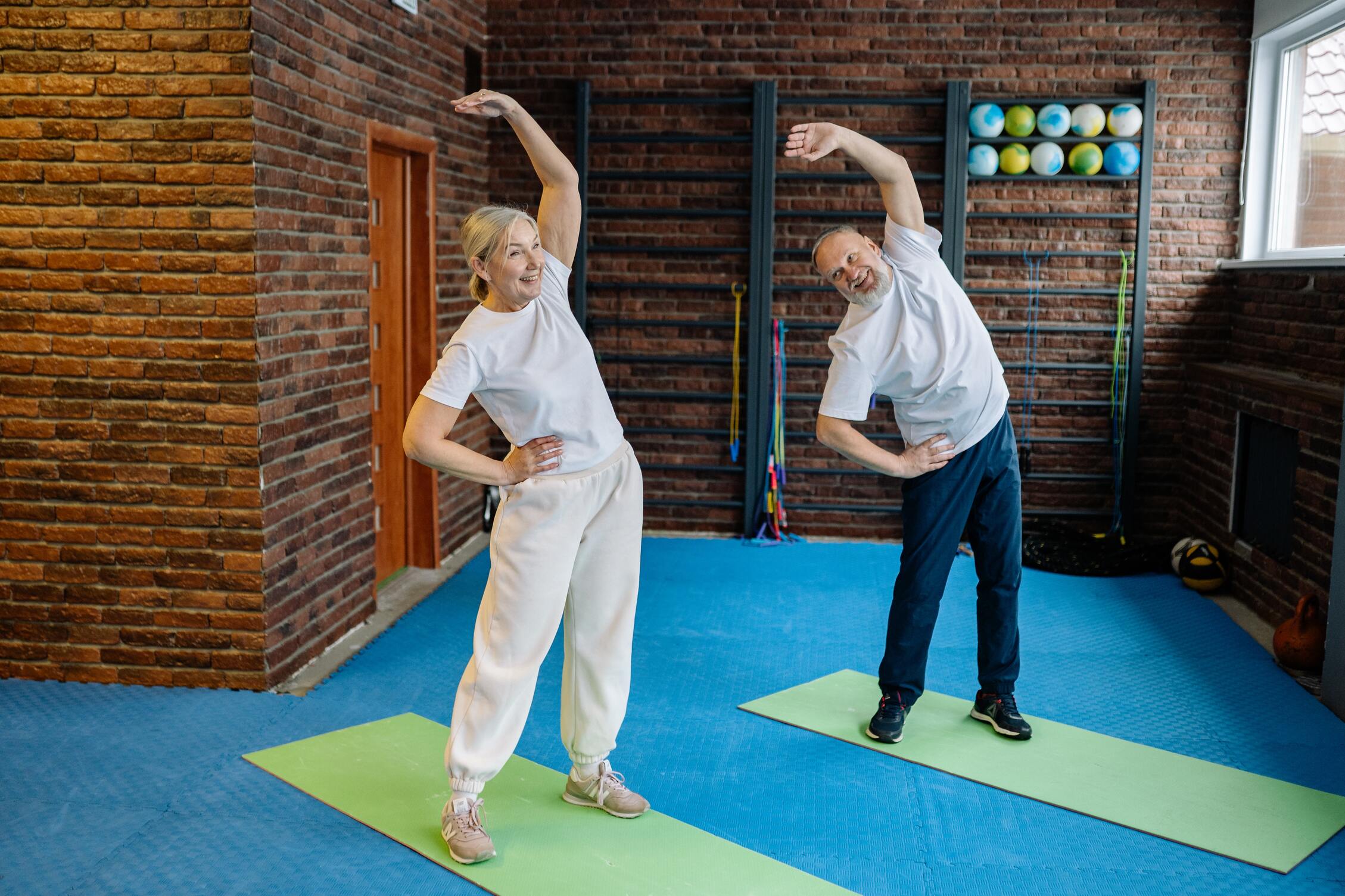 two seniors stretching in studio before dance class